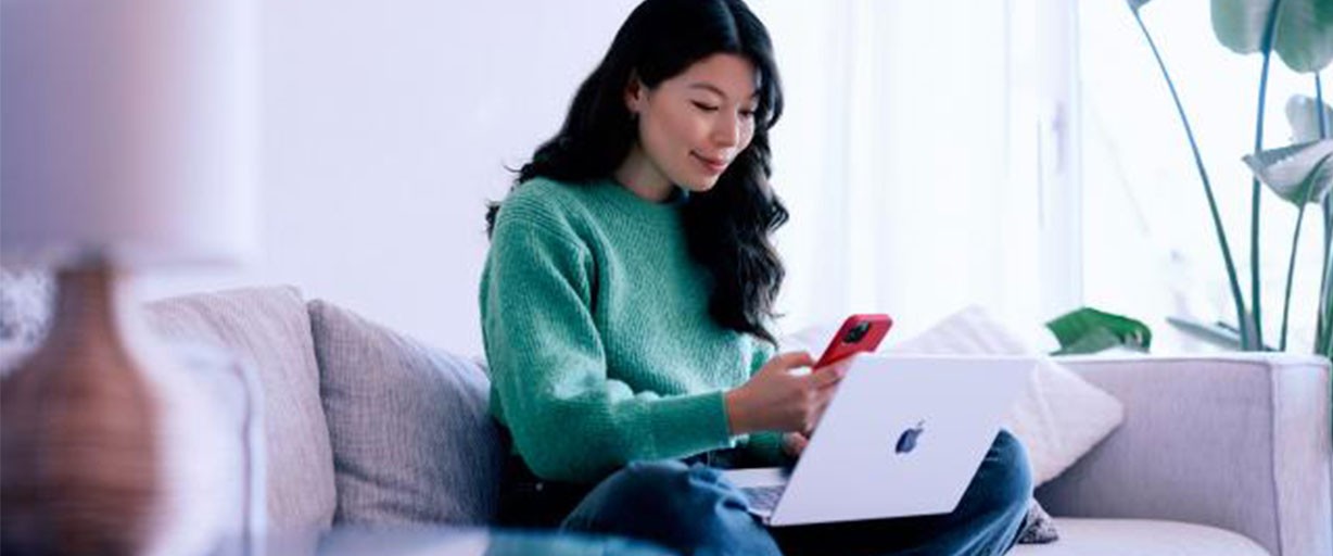 femme avec ordinateur et téléphone portable réalisant une transaction