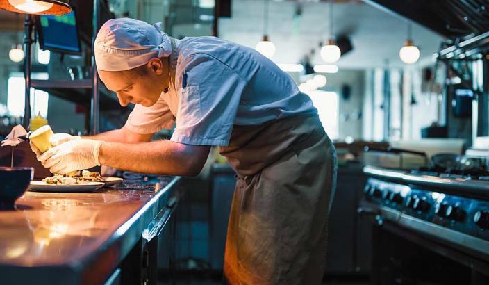 Cuisiner occupé au dressage des assiettes