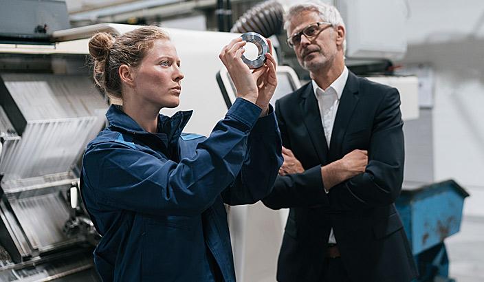 Deux entrepreneurs qui vérifient la qualité d'une pièce métallique