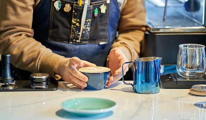 Restaurateur qui rempli une tasse de café