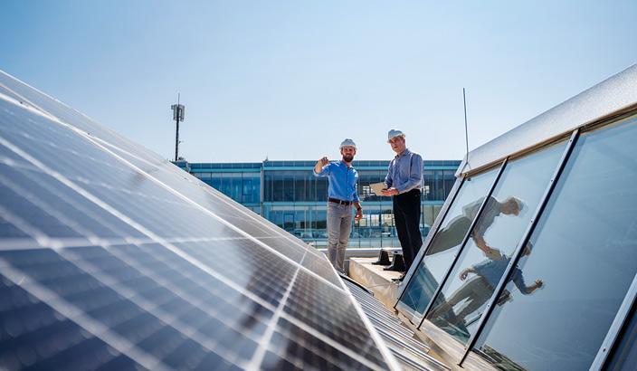 2 hommes sur un bâtiment avec panneau solaire