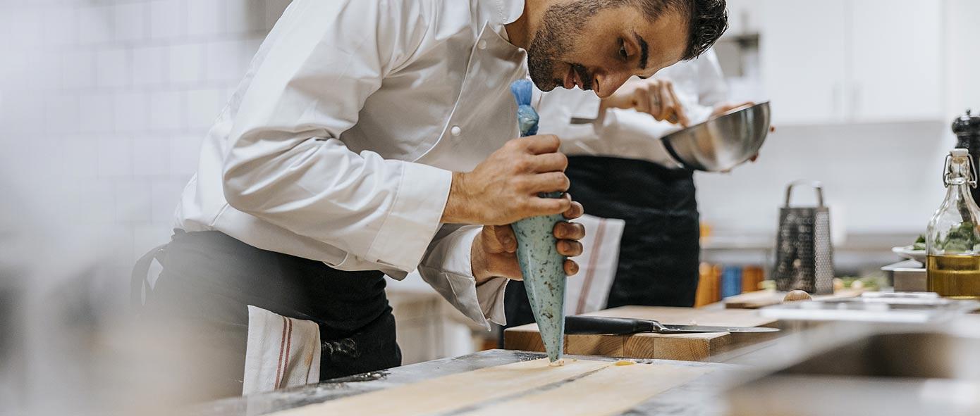 Cuisinier qui met tout son talent à la préparation de pâtes fraîches