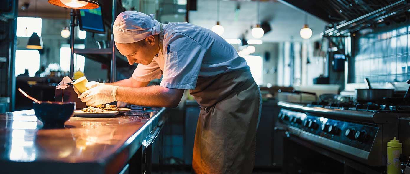 Cuisinier occupé à dresser des assiettes 