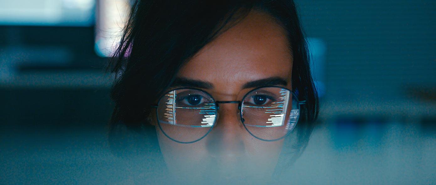 Entrepreneuse portant des lunettes avec en reflet l'écran de son ordinateur