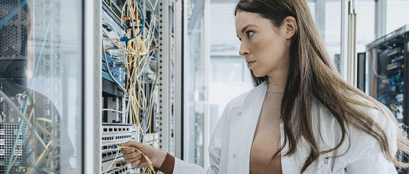 Informaticienne qui branche un serveur informatique