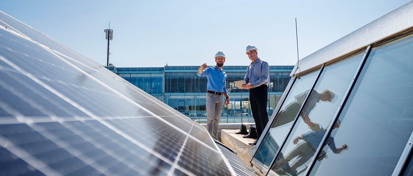 2 entrepreneurs discutent sur un toit avec panneau solaire