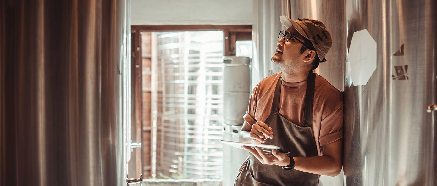 Homme dans une brasserie qui vérifie une cuve