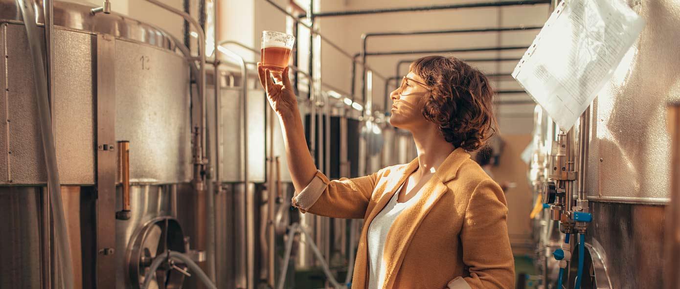 Femme dans une brasserie qui contrôle la qualité du produit