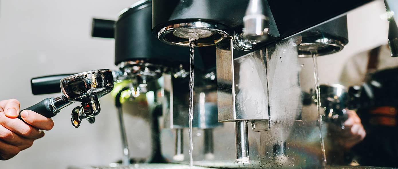 Restaurateur qui prépare un café sur une machine manuelle