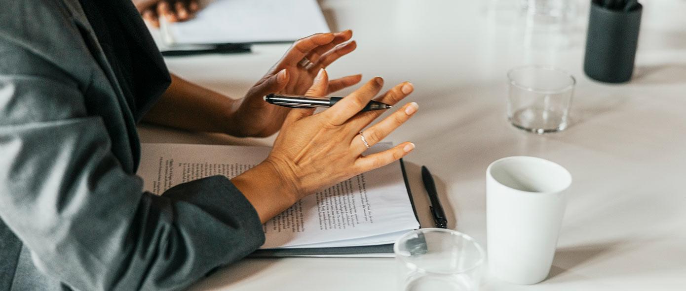 Collaboratrice assise à son bureau avec des documents posés devant elle sur son bureau