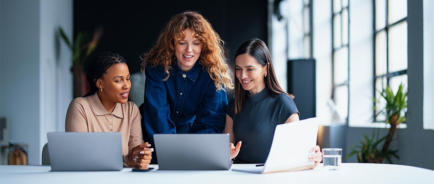Trois collaboratrices qui travaillent devant leur ordinateur