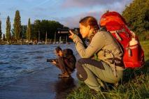 fille prenant une photo au bord du lac
